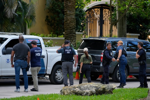 Law enforcement agents stand at the entrance to a property belonging to rapper Sean "Diddy" Combs, Monday, March 25, 2024, on Star Island in Miami Beach, Fla. (AP Photo/Rebecca Blackwell)
